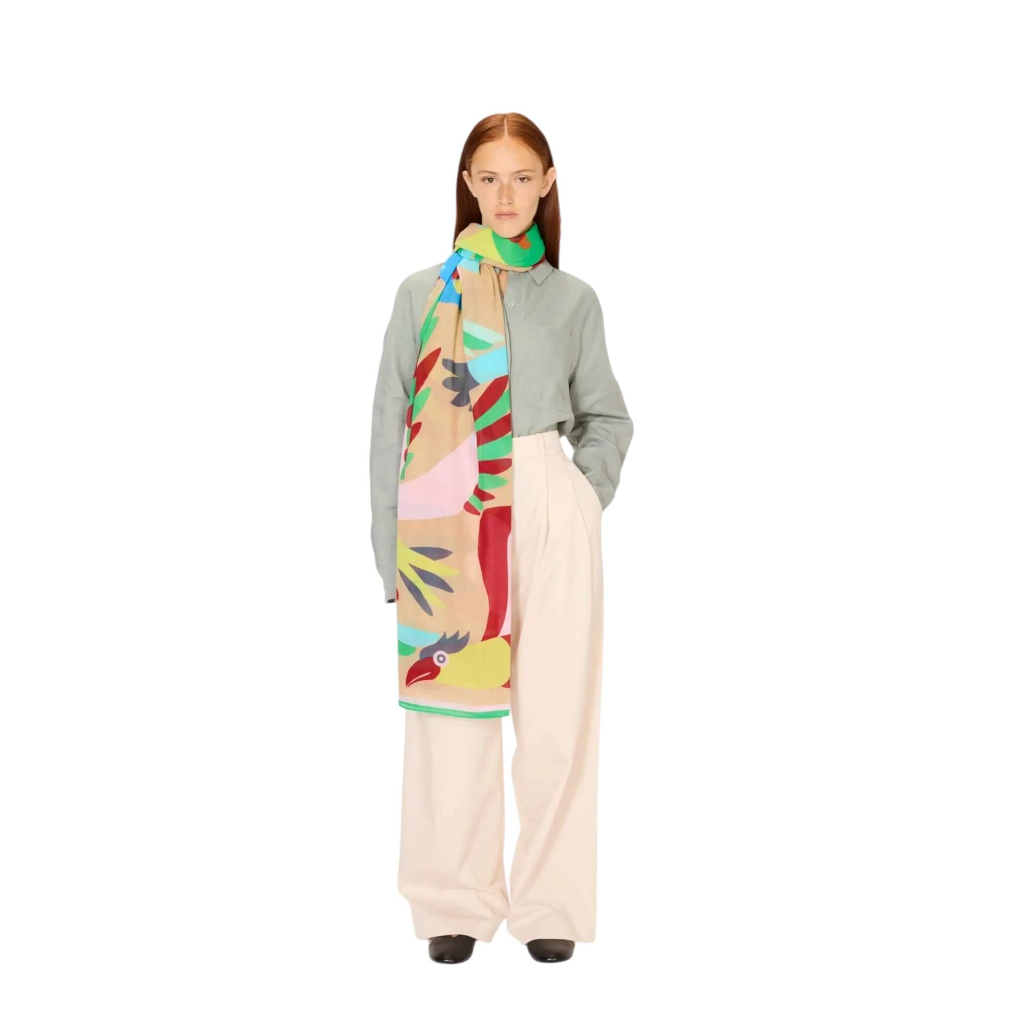 Model wearing the hand-painted Sciarpa Voyage scarf, showcasing vibrant colors and patterns, ideal for summer styling.